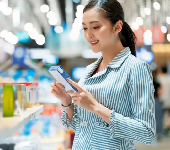 girl in supermarket reading food label off a food product