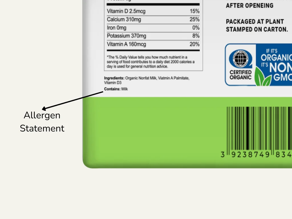 An allergen statement closely pointed out on the side of a milk carton.